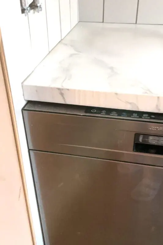 Smeg dishwasher with a DIY shiplap backsplash.